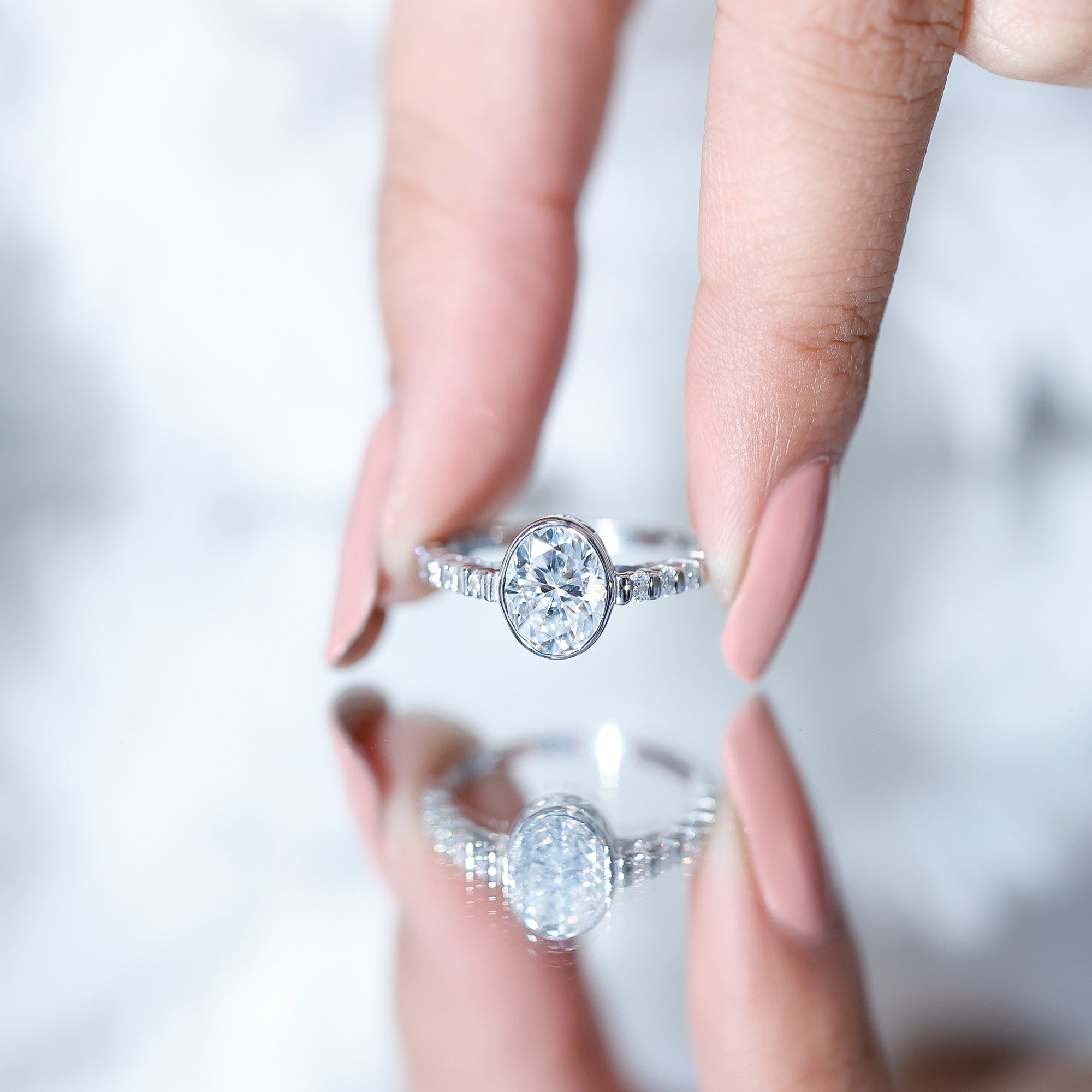 Bezel Set Moissanite Oval Engagement Ring with Side Stones